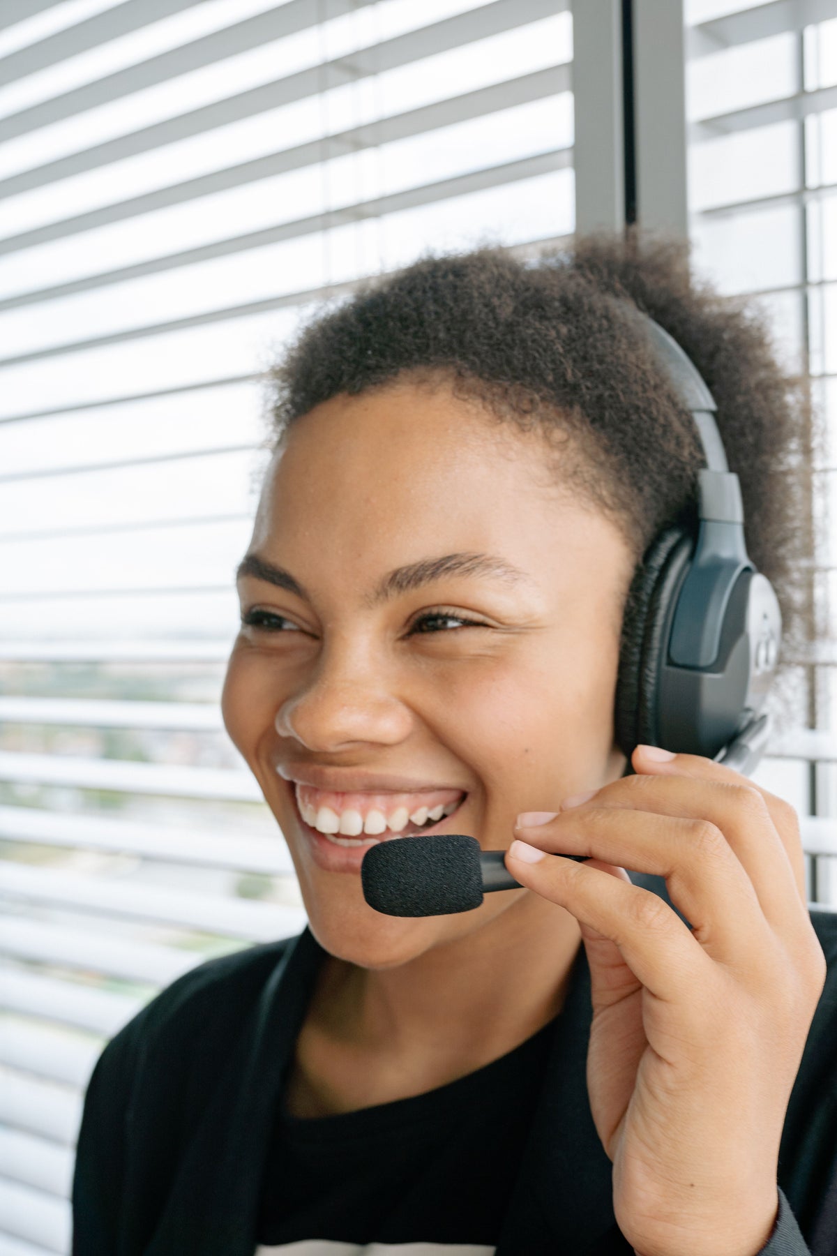 Customer support professional smiling while wearing a headset